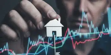 Hand holding house key with financial charts in background
